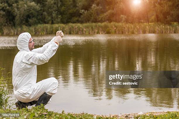 scientist examing toxic water - water beaker stock pictures, royalty-free photos & images