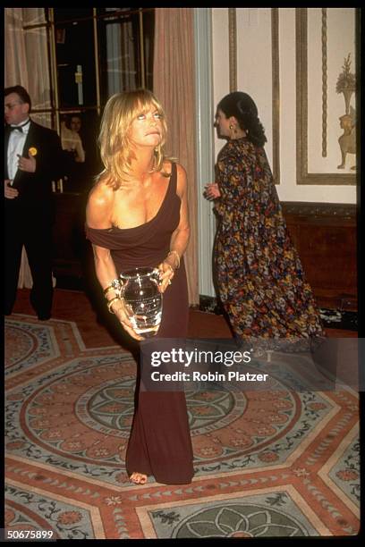 Actress Goldie Hawn making a face w. Her award at the 12th annual American Museum of the Moving Image ceremony at the Waldorf-Astoria. She is wearing...