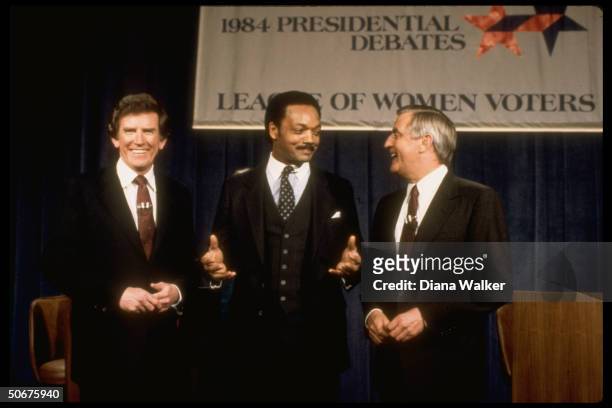 Dem. Presidential hopefuls Gary Hart, Jesse Jackson & Walter Mondale smiling onstage together after a primary debate before the League of Women...