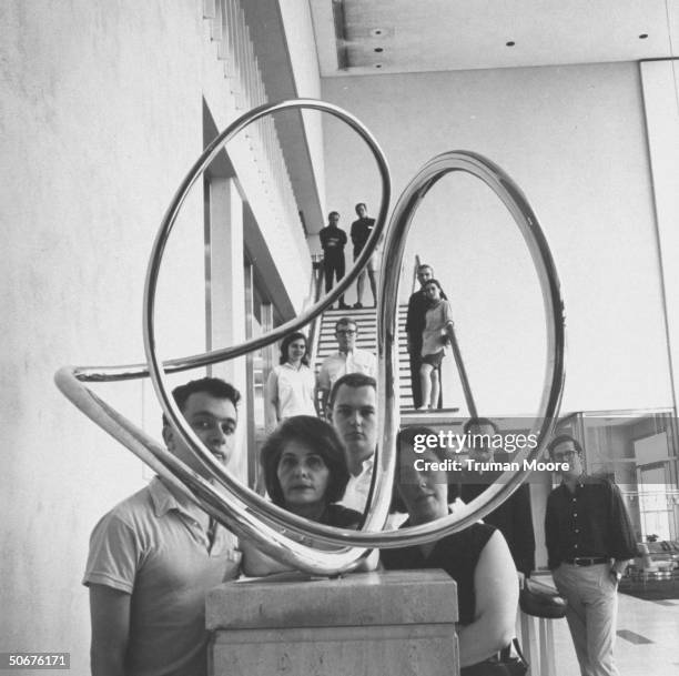Graduate students at the University of Pennsylvania's Annenberg School of Communications looking at a sculpture by Jose Rivera.