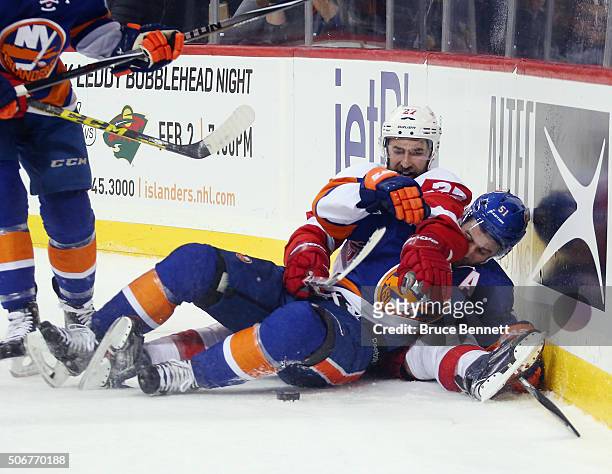 Kyle Quincey of the Detroit Red Wings and Frans Nielsen of the New York Islanders battle for the puck during the second period at the Barclays Center...