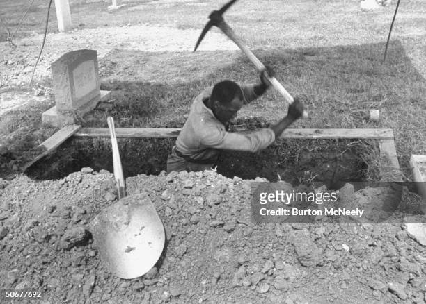 An unidentified man digs grave for one of the four victims of the 16th Street Baptist Church bombing, Birmingham, Alabama, late September 1963.