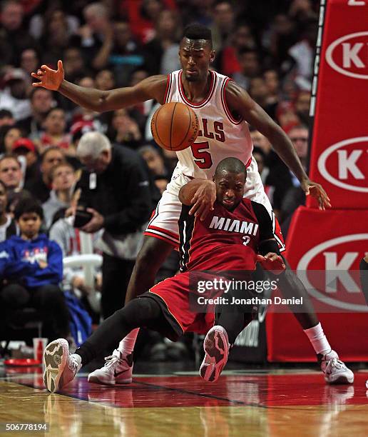 Dwyane Wade of the Miami Heat gets off a pass as he slips and falls into Bobby Portis of the Chicago Bulls at the United Center on January 25, 2016...