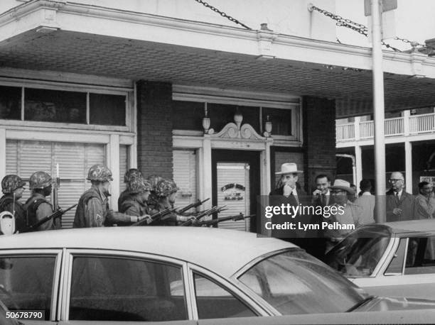 Troops patroling streets during riots vs enrollment of African American, James H. Meredith, at Univ. Of Mississippi.