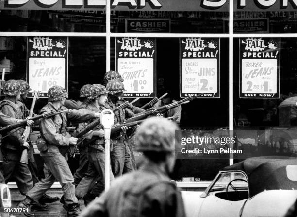 Troops patroling streets during riots vs enrollment of African American, James H. Meredith, at Univ. Of Mississippi.