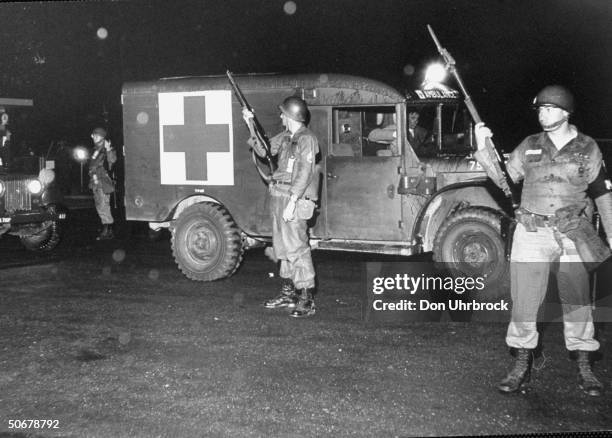 Troops guarding ambulance carring body of French newsman, Paul Guihard, killed during anti-integration riots at Univ. Of Mississippi.