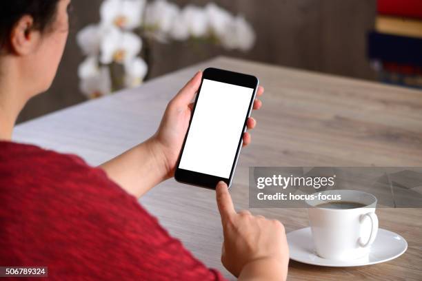 woman using blank white screen smart phone - computer screen over shoulder stock pictures, royalty-free photos & images