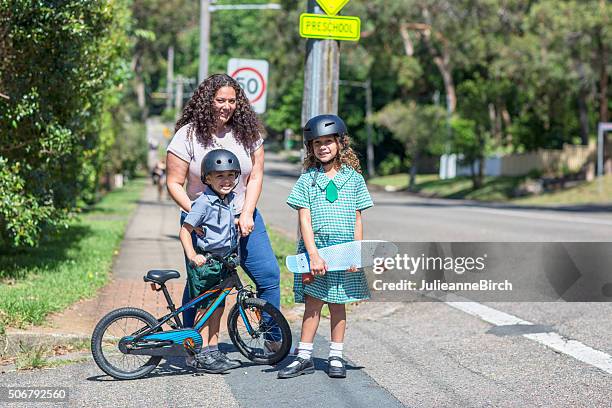 mutter und kinder, die über die straße zur schule - australian aboriginal children stock-fotos und bilder