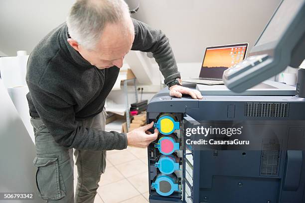 hombre cambio de cartucho de impresión - impresora fotografías e imágenes de stock