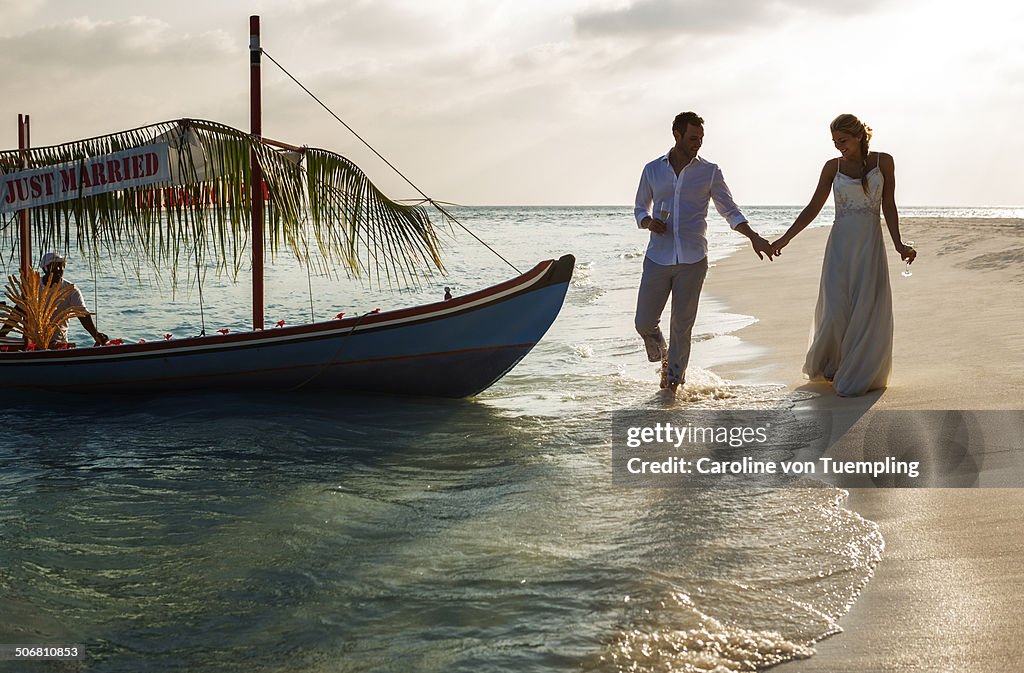 Young wedding couple walking on beach