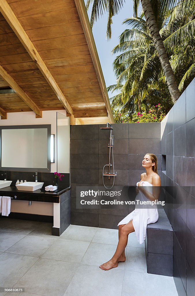 Woman sitting in open air bathroom