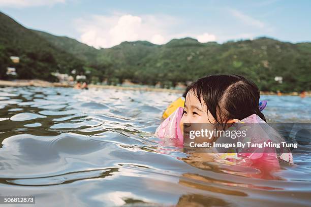 child swimming joyfully in the sea - brazaletes acuáticos fotografías e imágenes de stock