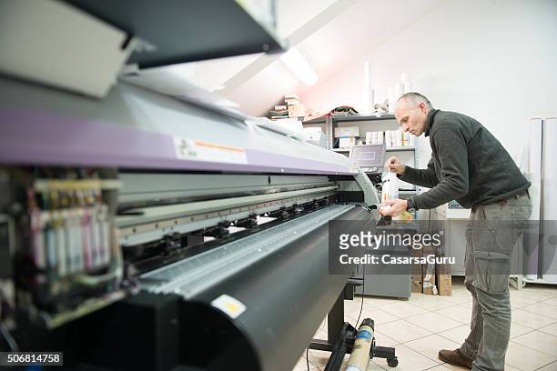 uomo pulizia stampante per grandi formati testa - digital printing foto e immagini stock