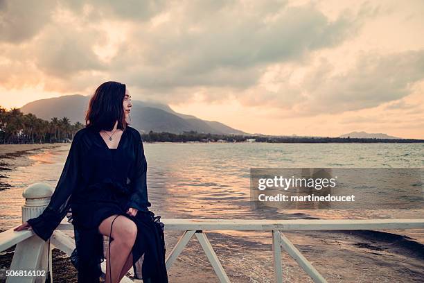 mystical jovem mulher sentada em um cais, pôr do sol, desfrutar da natureza. - puerto plata imagens e fotografias de stock