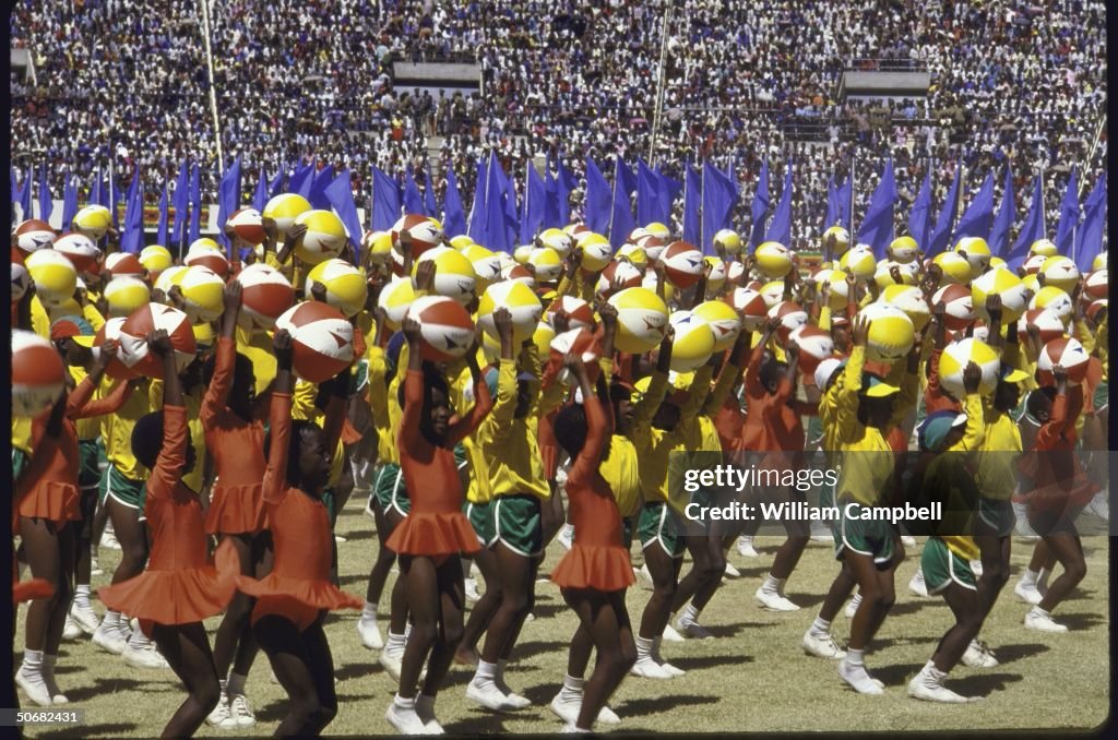 Children in bright uniforms performing d