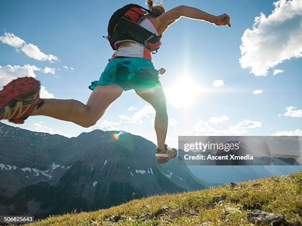 trail runner bounds along mountain ridge crest - carrera de campo través fotografías e imágenes de stock