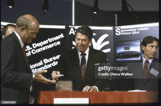 President Ronald W. Reagan at Superconductivity conference using tweezers.