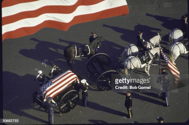 Horse-drawn caisson bearing flag-draped casket of John F, Kennedy leads funeral cortege and is followed by riderless horse, Washington, D.C.