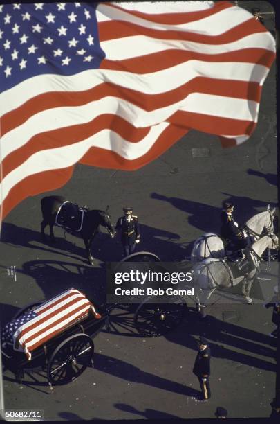 Horse-drawn caisson bearing flag-draped casket of John F, Kennedy leads funeral cortege and is followed by riderless horse, Washington, D.C.