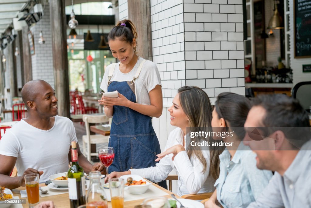 Kellnerin serviert eine Gruppe von Menschen in einem Restaurant