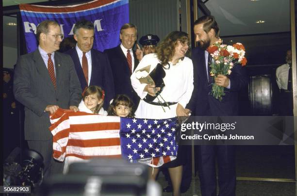 American flag held by happy Soviet emigre wife/mom, Elena and daughters Katya and Masha, celebrating reunion with husband/dad refusenik Yuri...