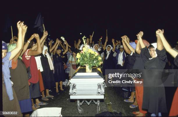 Mothers of Disappeared raising linked hands around the coffin of assassinated Human Rights Comm. President Herbert Anaya Sanabria.