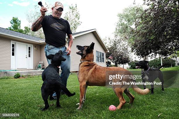 Sergeant 1st Class Matthew Bessler plays with his dogs Ziva and Mike 5 "Michael", center, at his home in Powell, WY on June 15, 2015. Sgt. Bessler is...