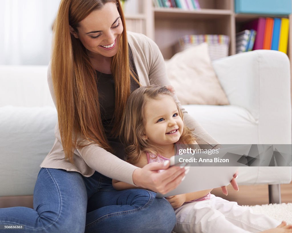 Mother and daughter have fun during the using digital tablet. Debica, Poland