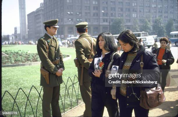 As police officers stand by, Estela Ortíz and Owana Madera march in protest near La Moneda Palace, Santiago, Chile, September 10, 1985. The women...