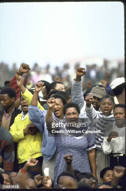 Mourners raise clench fists during mass funeral of 18 blacks killed during unrest in Duncan Village near East London.