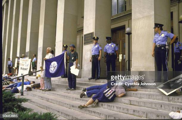 Police nearby as Anti-nuclear arms protestors lie-in at Pentagon also hold signs and photos regarding the loss of life and horrors of bombing of...