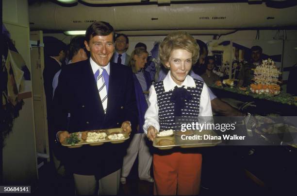 Navy Secretary John F. Lehman, Jr. With Nancy Reagan carrying lunch trays on board USS America.