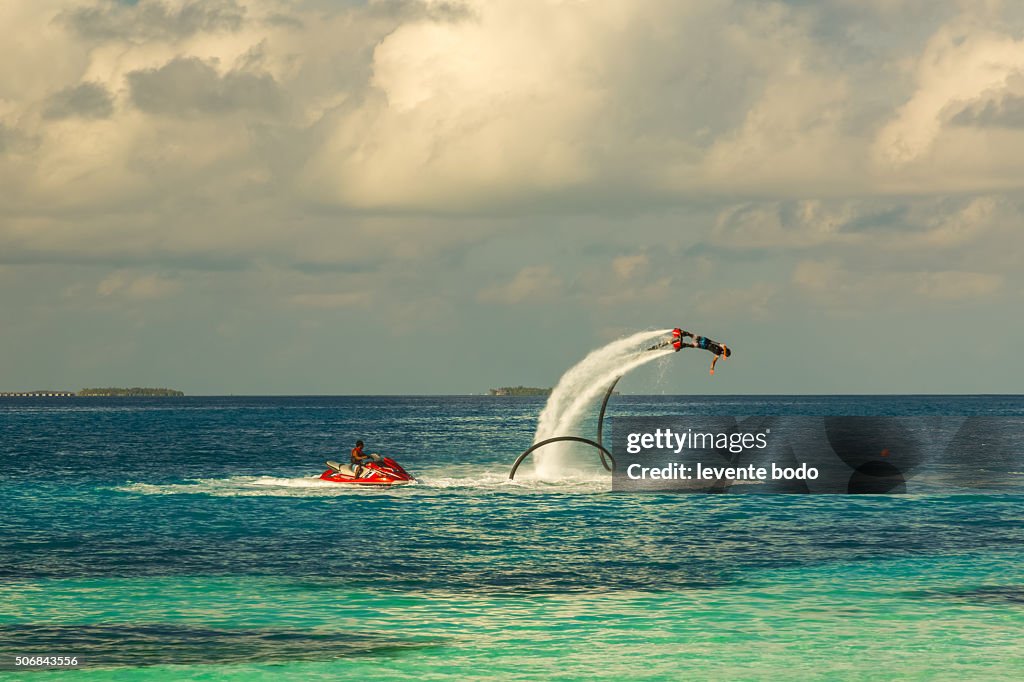 Silhouette of a fly board rider at the tropical lagoon