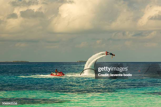 silhouette of a fly board rider at the tropical lagoon - rocket booster stock pictures, royalty-free photos & images