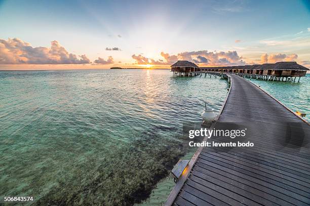 sunset on maldives island, water villas resort - jetty stock pictures, royalty-free photos & images