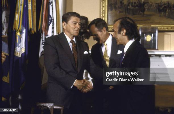 Author/Holocaust Comm. Chrmn. Elie Wiesel shaking hands with US Pres. Ronald W. Reagan during presentation ceremony of Congressional Gold Medal with...