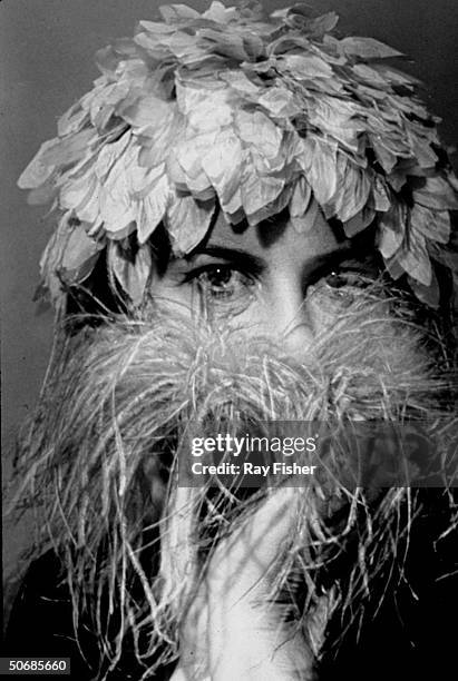 Actress Alice Pearce wearing a hat with lots of leaves as she holds a feather boa in front of her face in the stage play Angel in the Wings.