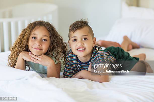 bruder und schwester auf einem bett - australian aboriginal children stock-fotos und bilder