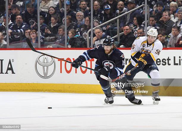 Kevin Fiala of the Nashville Predators passes the puck past Matt Halischuk of the Winnipeg Jets during first period action at the MTS Centre on...