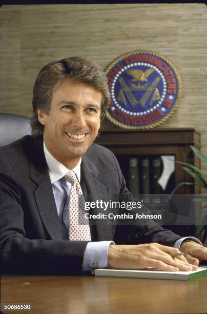 Chairman of the FCC Denis Patrick sitting in his office with the FCC seal in the background.