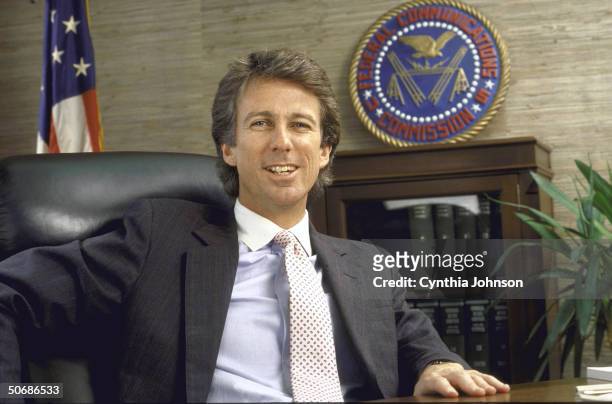 Chairman of the FCC Denis Patrick sitting in his office with the FCC seal in the background.