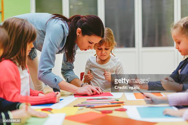 children making origami in a preschool - origami instructions stock pictures, royalty-free photos & images