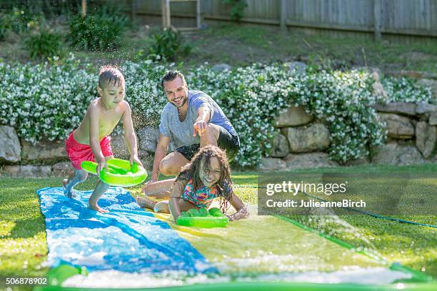 family having fun with water - two kids playing with hose stock pictures, royalty-free photos & images