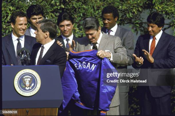 United States President Ronald W. Reagan holding his jacket gift from the New York Mets with Fred Wilpon, president of the Mets standing at the...