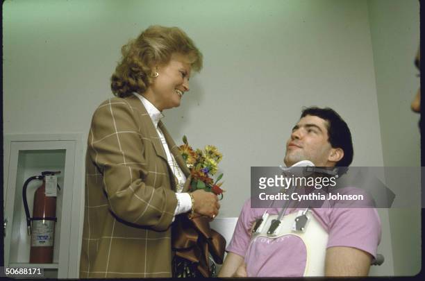 Wife of German Chancellor, Mrs. Helmut Kohl clutching bouquet while chatting wtih patients at the National Rehabilitation Hospital.