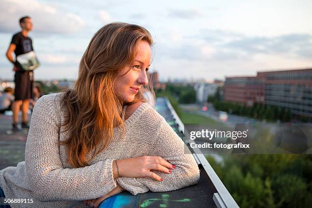 young adults sitting on a roof, back lit - berlin graffiti stock pictures, royalty-free photos & images