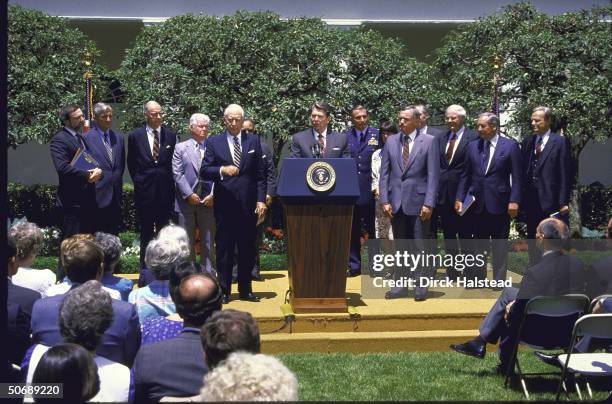 Members of the Rogers Commission present the Challenger Accident Report to President Reagan in the Rose Garden. Richard Feynman, Joseph Sutter,...