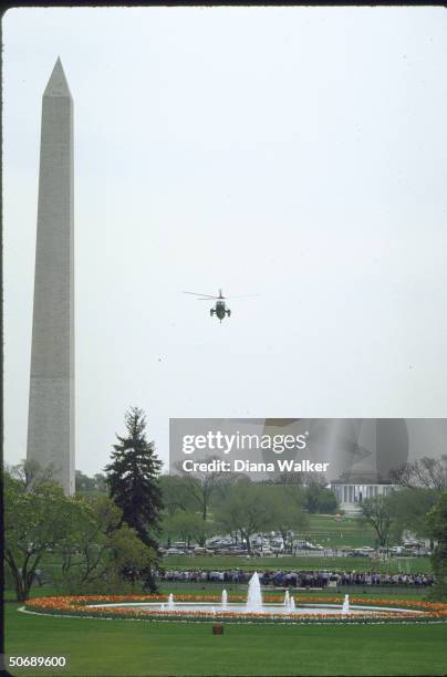 Marine One helicopter carrying US Pres. And Mrs. Ronald W. Reagan flying in from weekend at Camp David with National Monument in background.