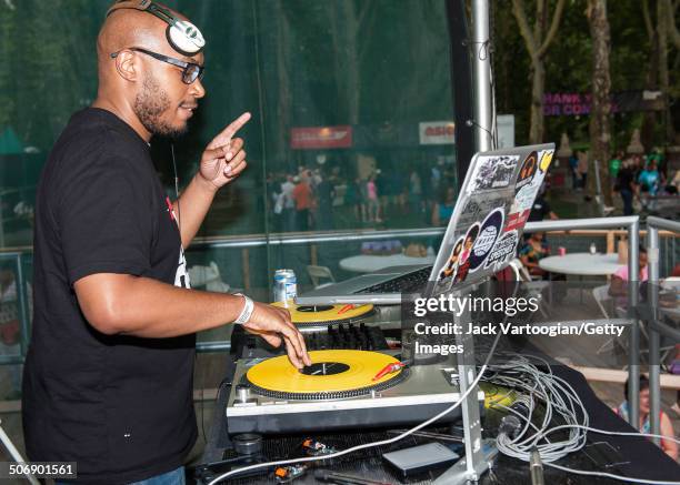 American DJ Raydar Ellis spins on turntables at a dual celebration of Blue Note's 75th anniversary and Okayplayer's 15th at Central Park SummerStage,...