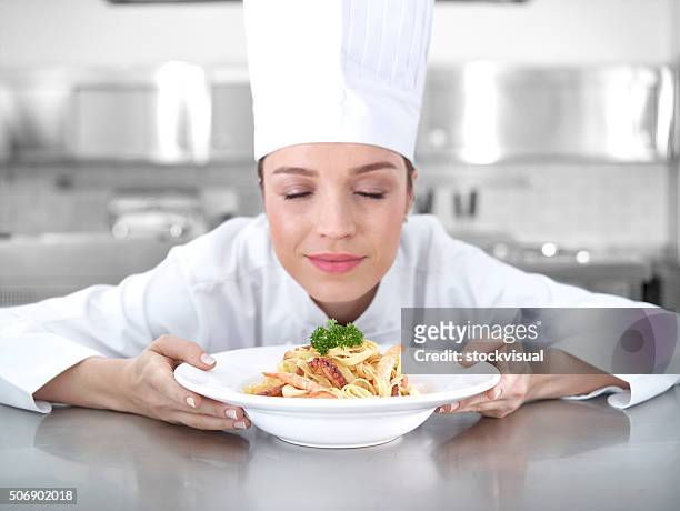 chef smelling shrimp pasta - chef smelling food stockfoto's en -beelden